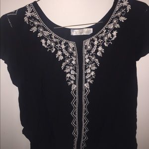 Black blouse with white floral pattern on front.